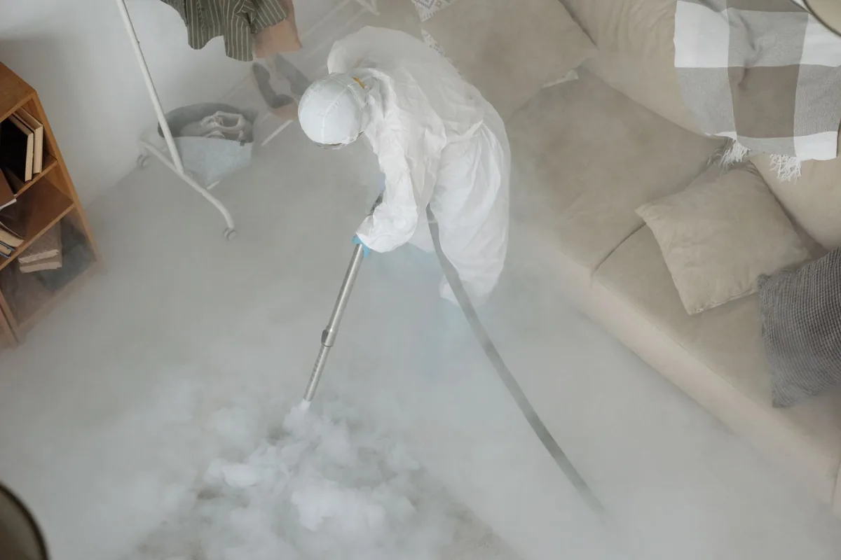 Biohazard cleanup technician in protective equipment, Lake City, AR
